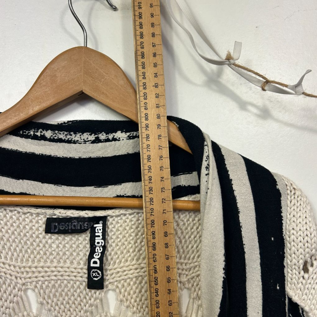 Cream and black striped knit sweater detail view on hanger