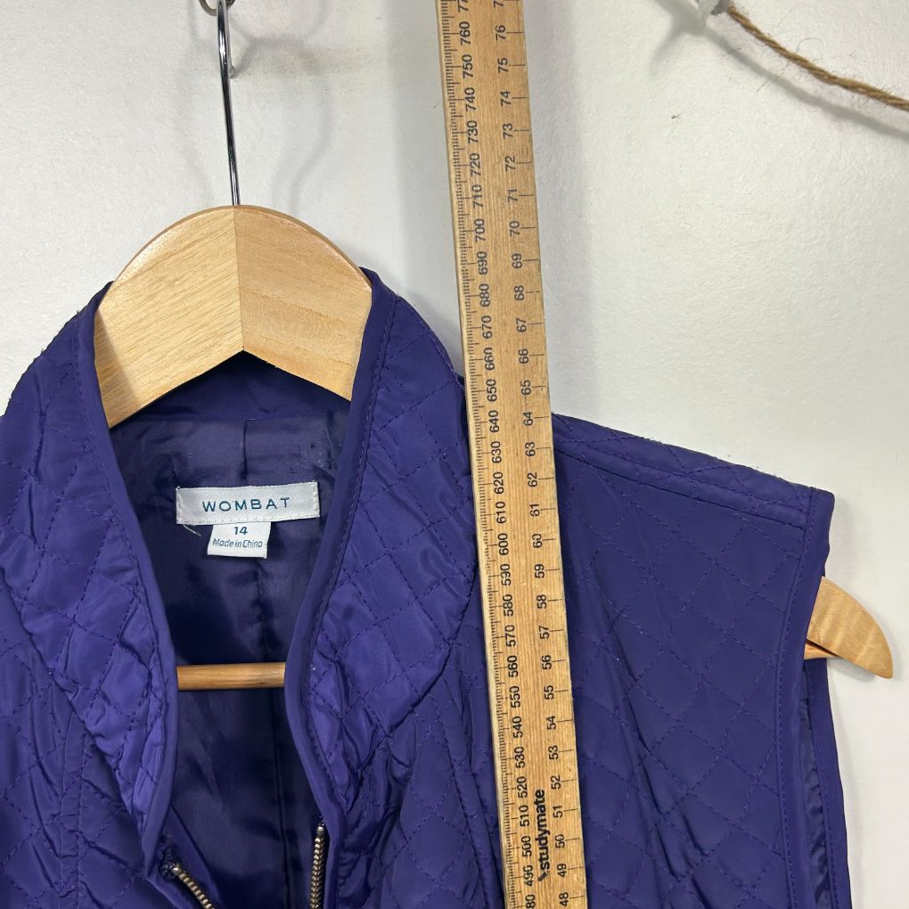 Navy blue jacket front view on wooden hanger with measuring tape