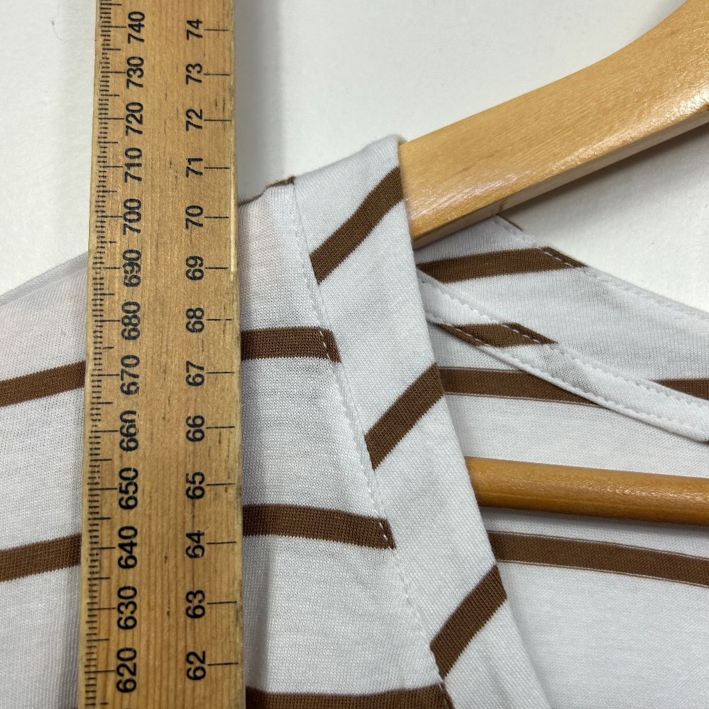 White and brown striped fabric detail view with wooden hanger and measuring ruler