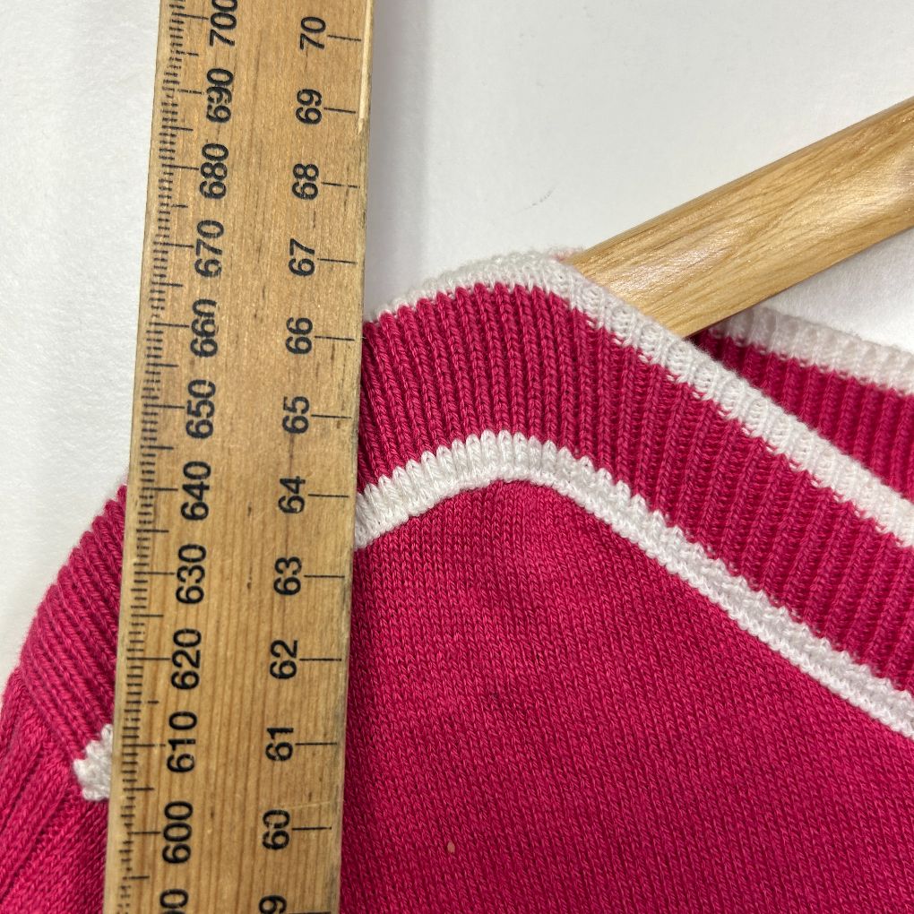 Red and white striped knit garment detail view with measuring tape