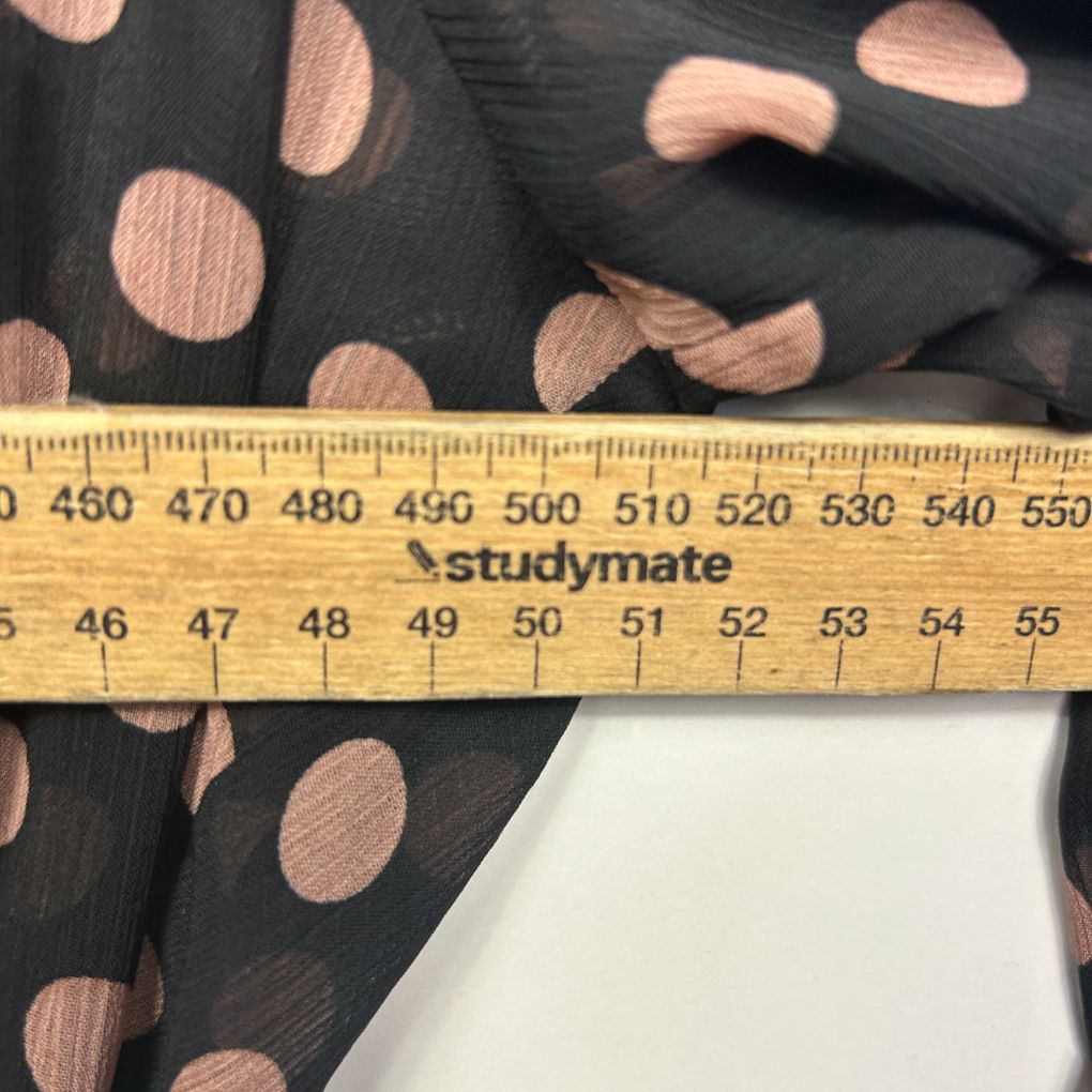 Black fabric with rose gold polka dots detail view with measuring ruler