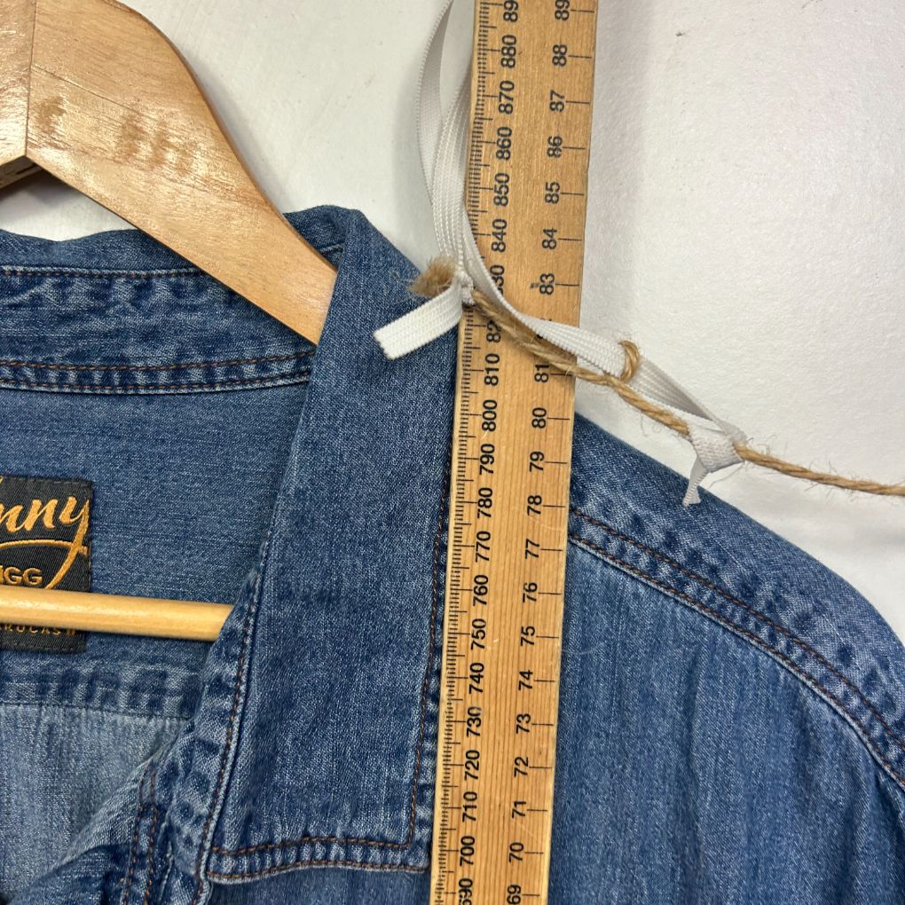 Blue denim jacket detail view with wooden hanger and measuring tape