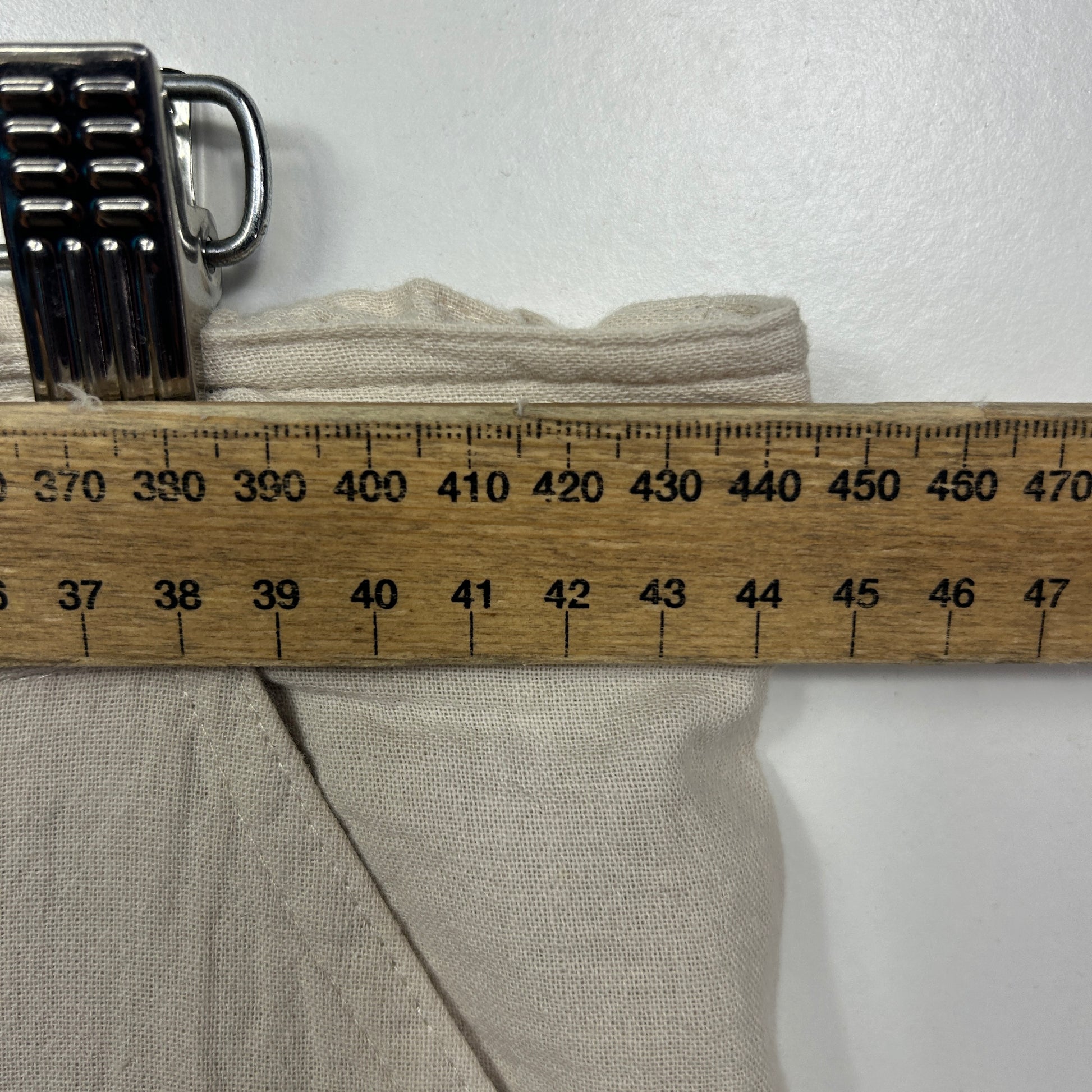 Beige garment detail view with measuring ruler