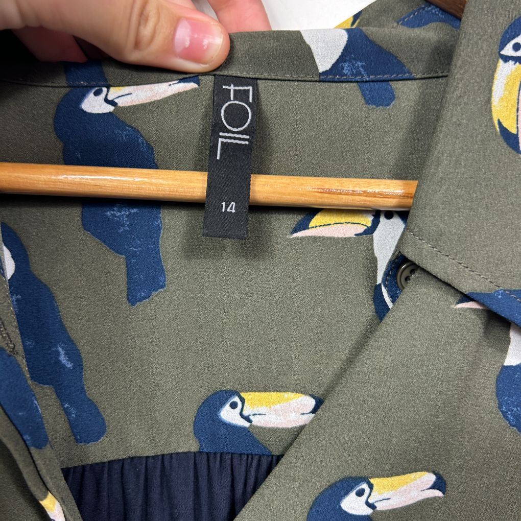 Olive green top with navy toucan graphic print detail view