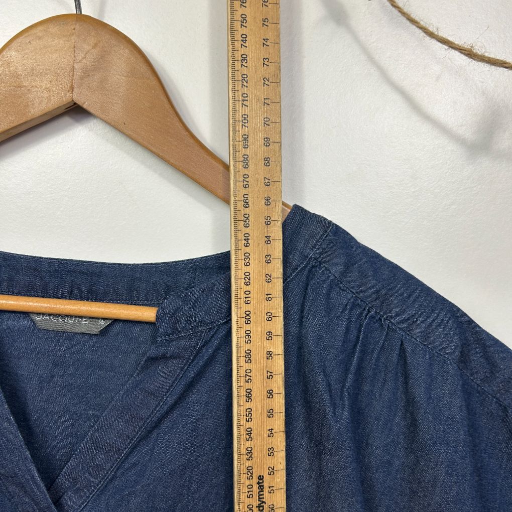 Navy denim shirt front view on wooden hanger with measuring tape