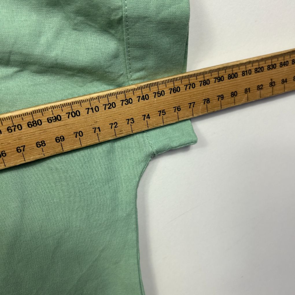 Mint green fabric detail view with measuring tape