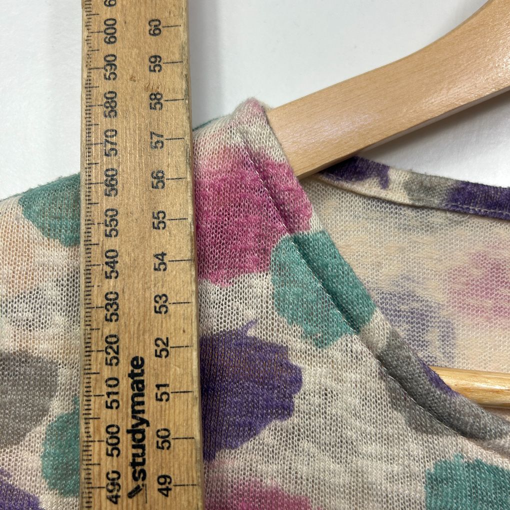 Multicoloured knit sweater detail view with measuring tape