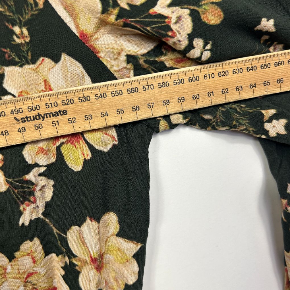 Dark green floral fabric with measuring tape detail view