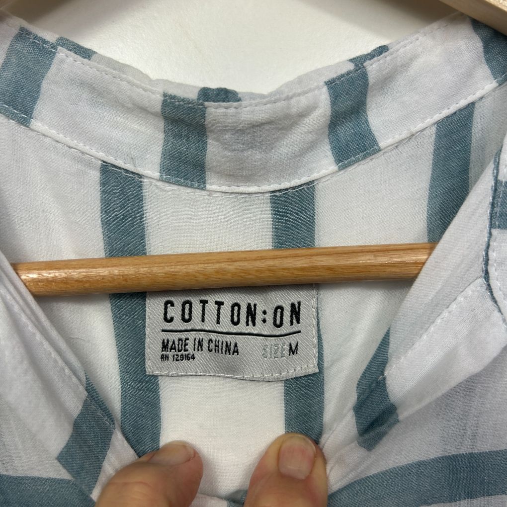 White and teal striped shirt label detail view