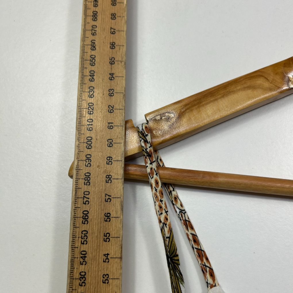 Wooden slingshot detail view with measurement ruler