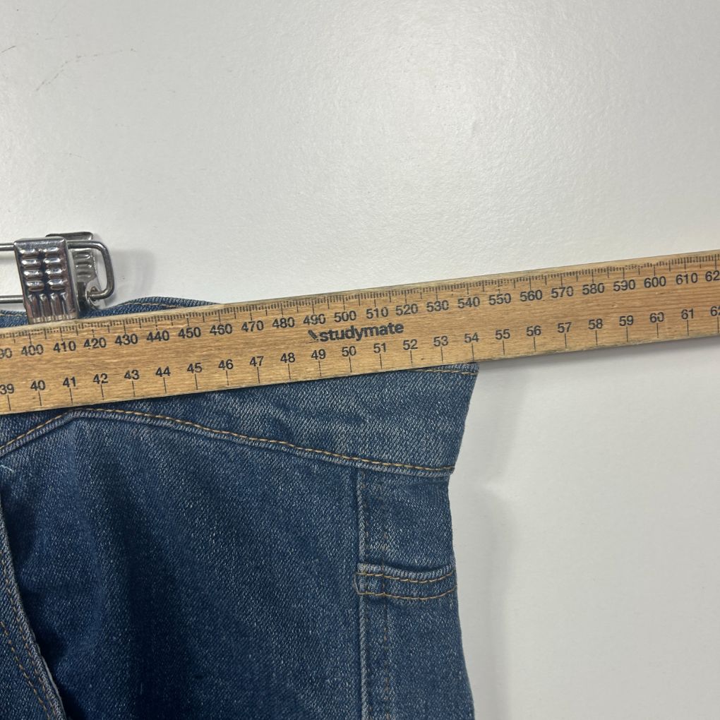 Dark blue denim jeans waist detail view with measuring tape