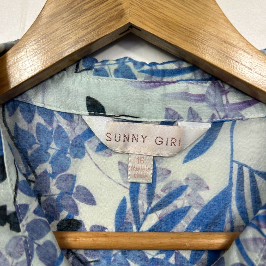 Blue and white floral blouse label view on wooden hanger