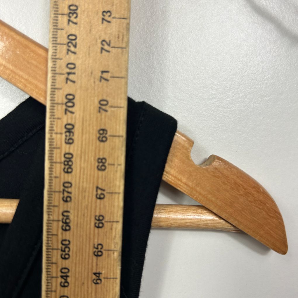 Black fabric with wooden ruler showing measurement detail view