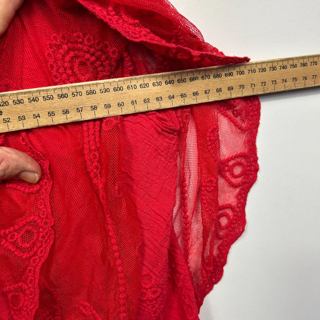 Red lace bra detail view with measuring tape