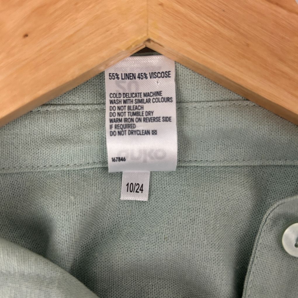 Sage green knit sweater label detail view