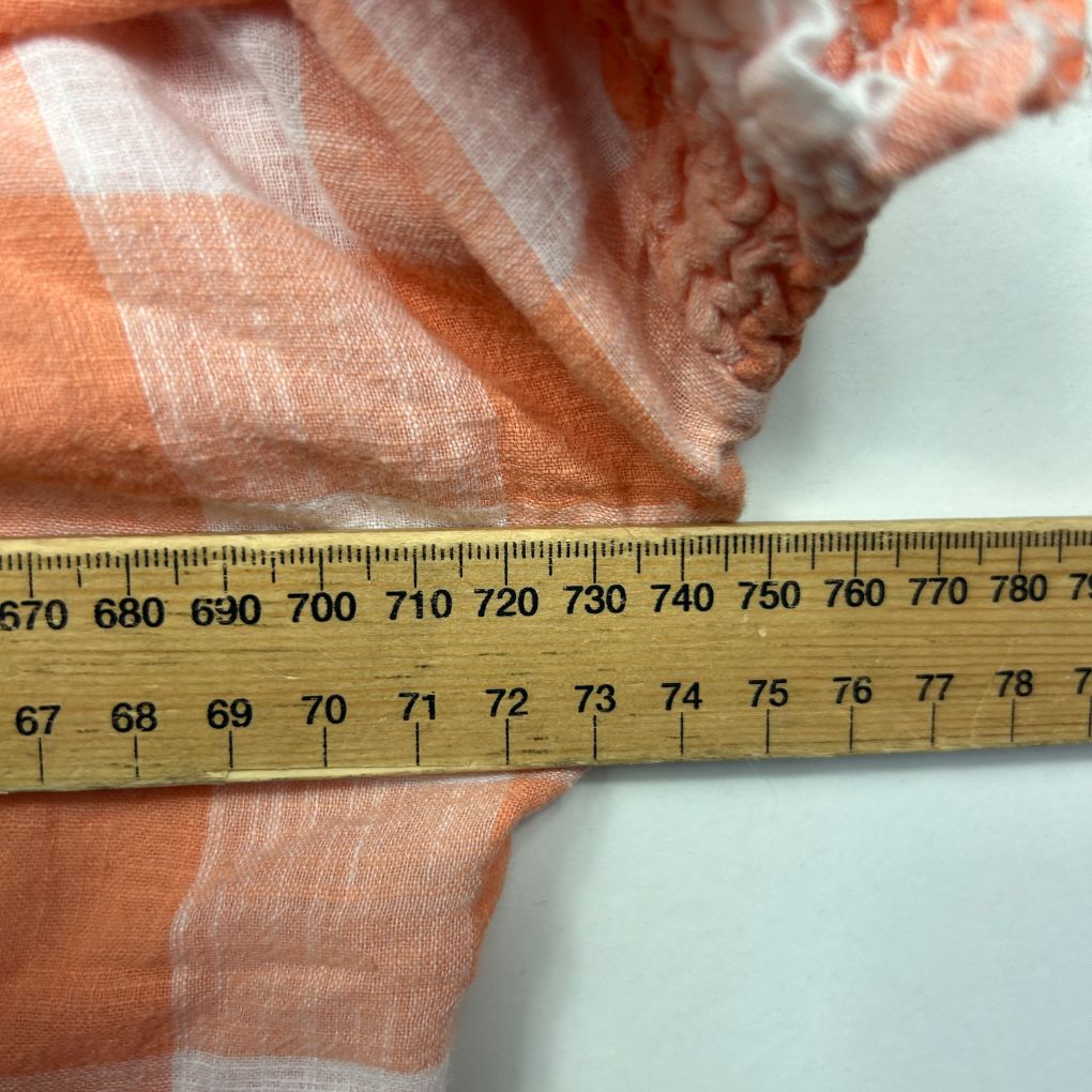 Orange striped fabric detail view with measuring tape