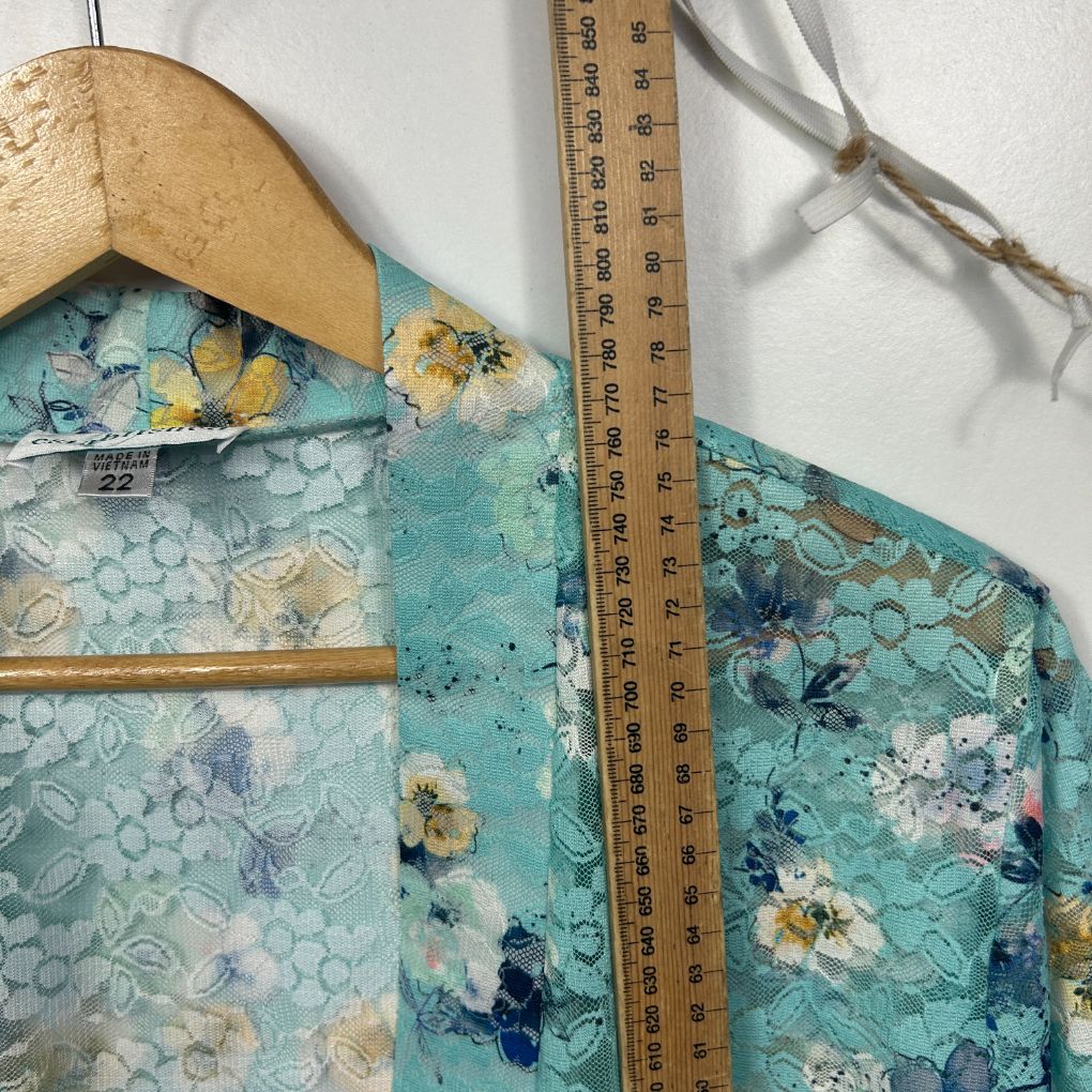 Turquoise floral dress detail view with measuring tape