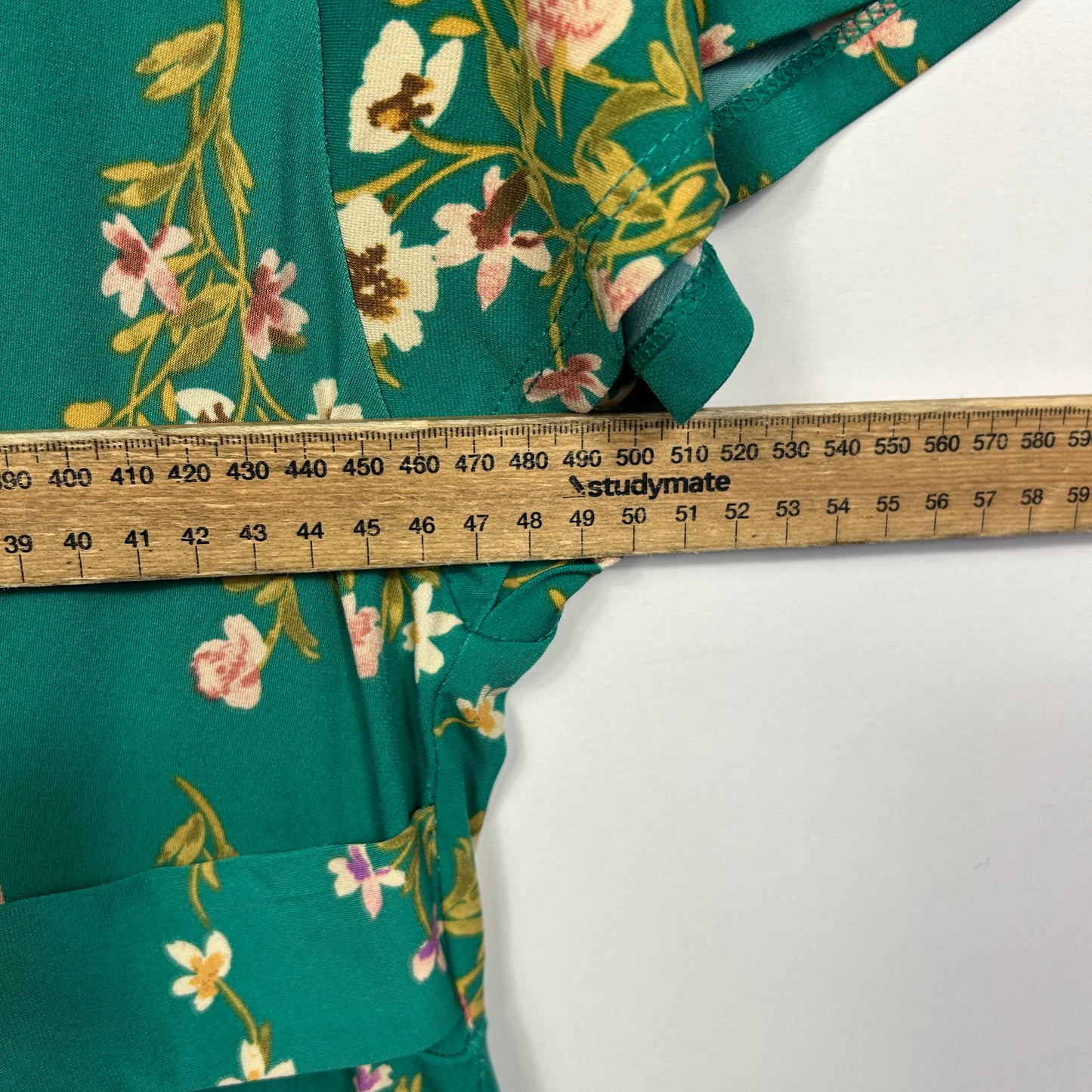 Green floral dress with measuring tape detail view