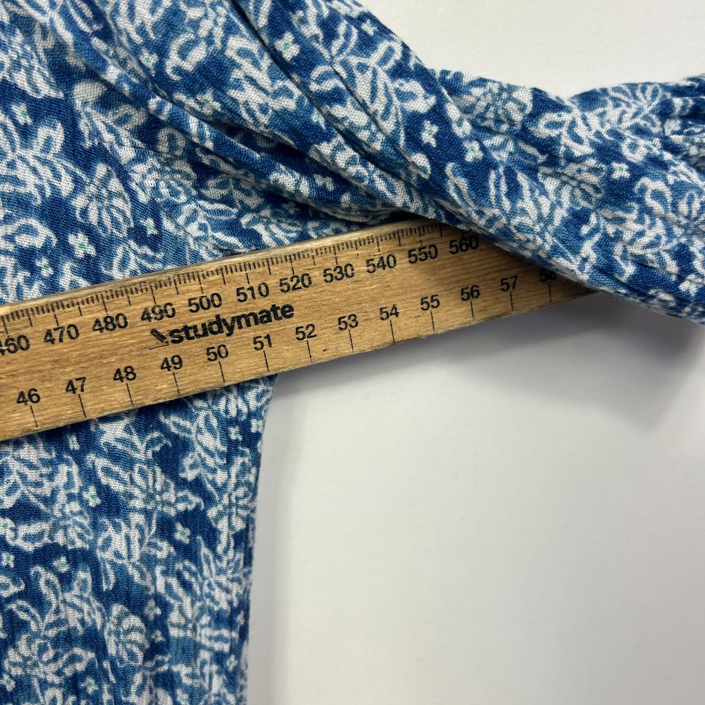Blue and white floral patterned fabric detail view with measuring tape