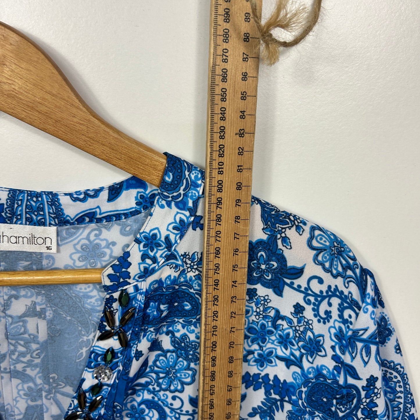 Blue and white floral blouse detail view on hanger