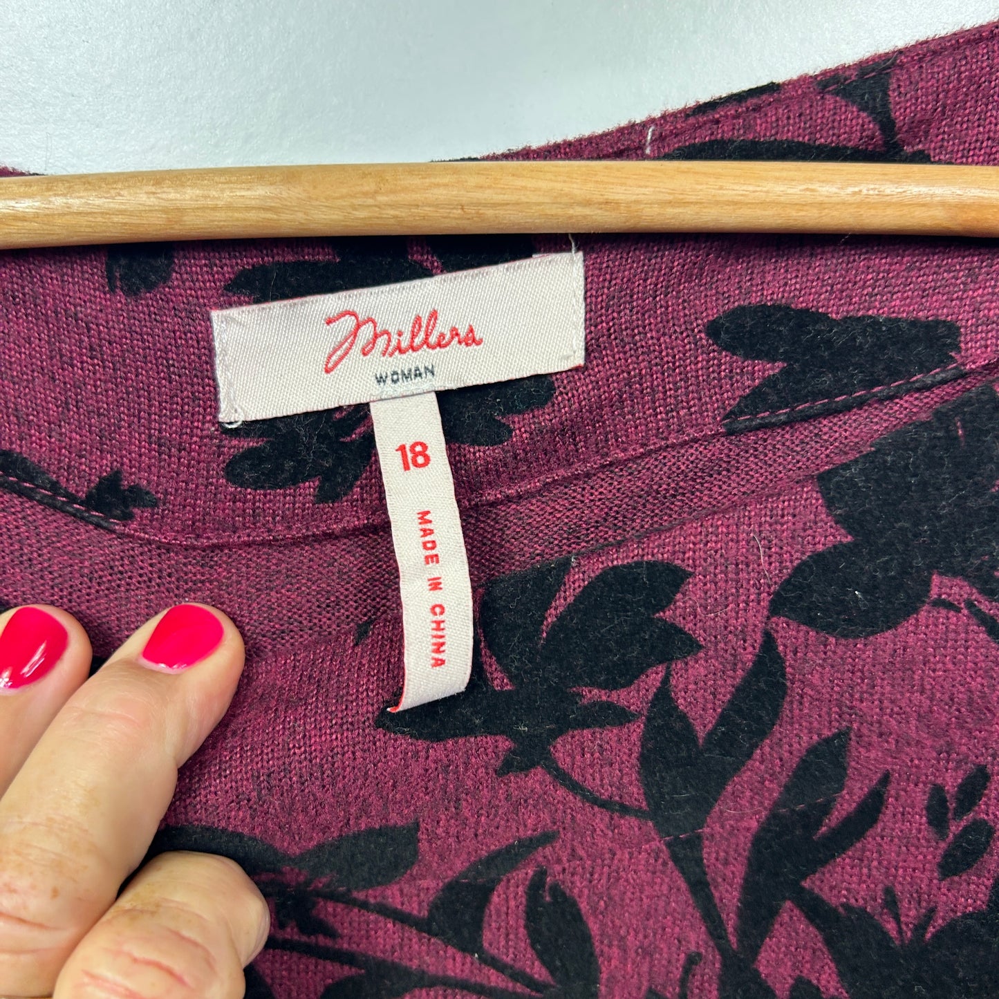 Purple knit top with black floral pattern label view