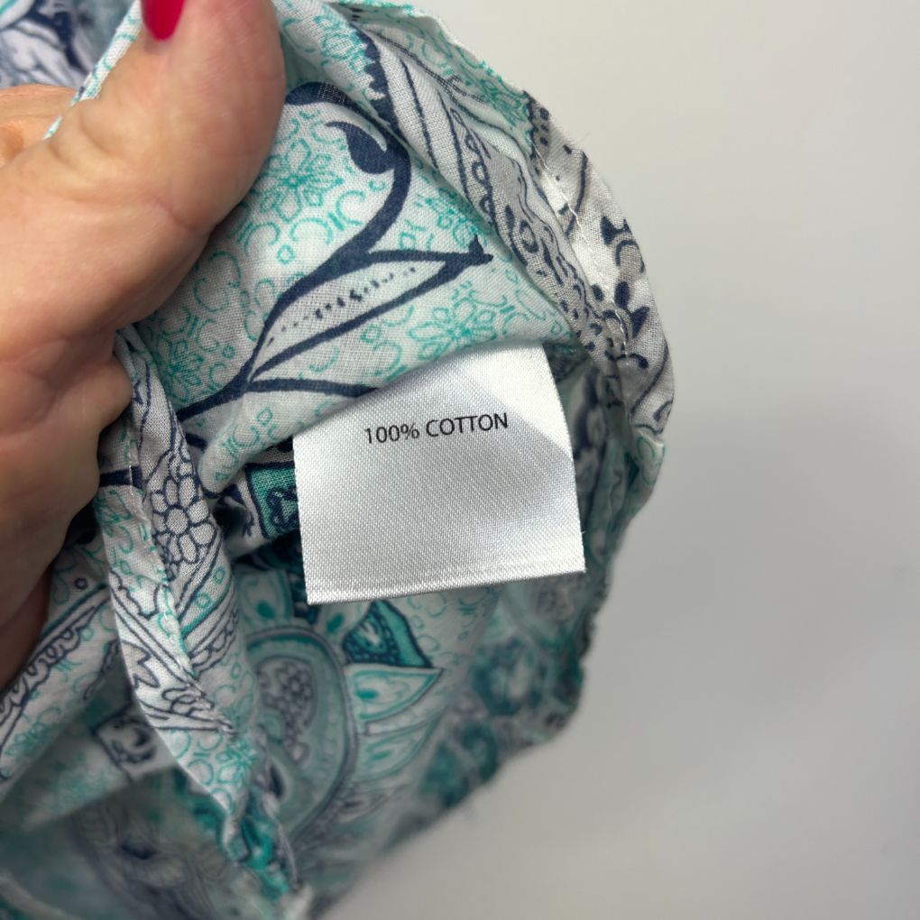 Green patterned fabric detail view showing 100% cotton label