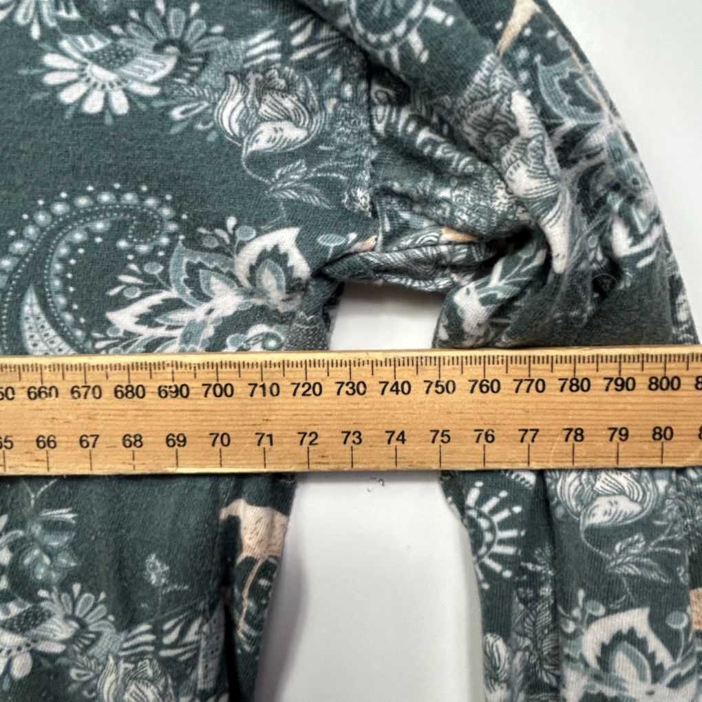 Teal floral fabric detail view with measuring tape