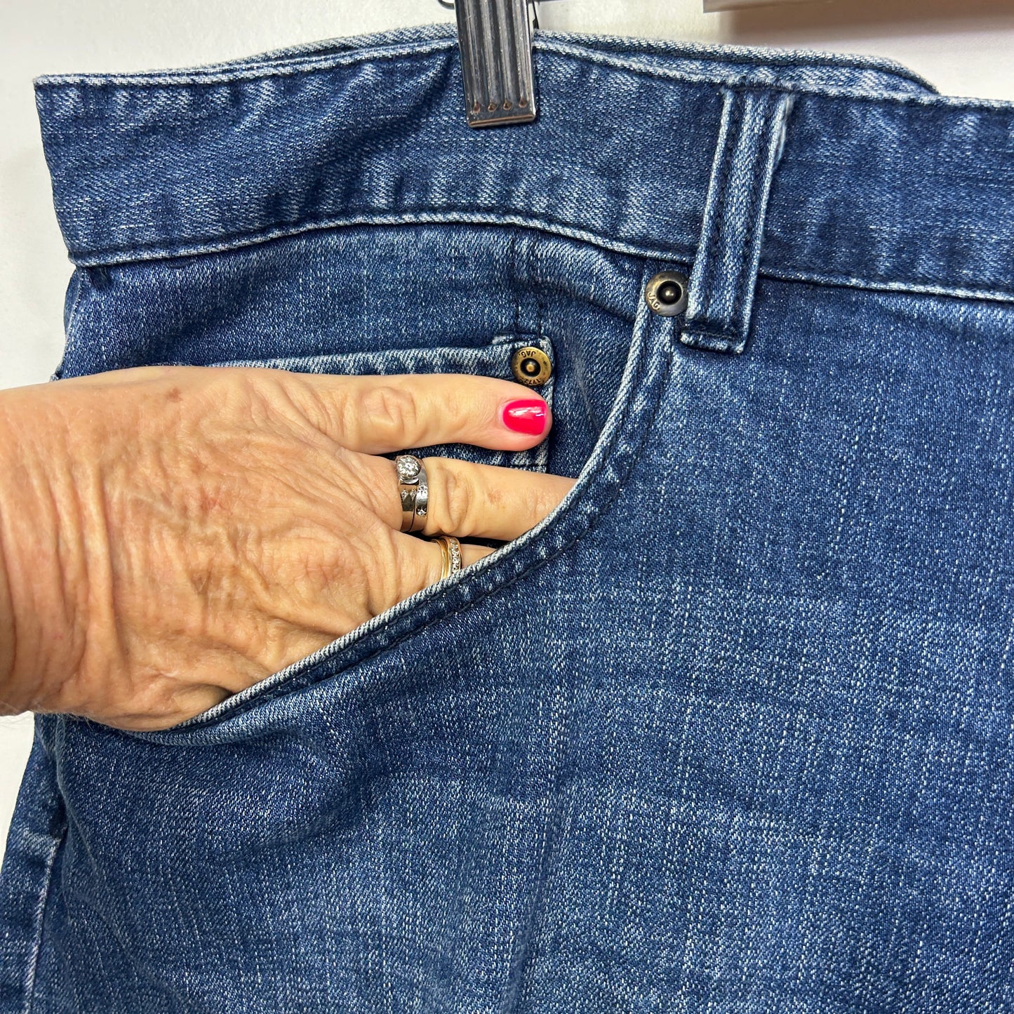 Blue denim jeans front detail view showing pocket and waistband