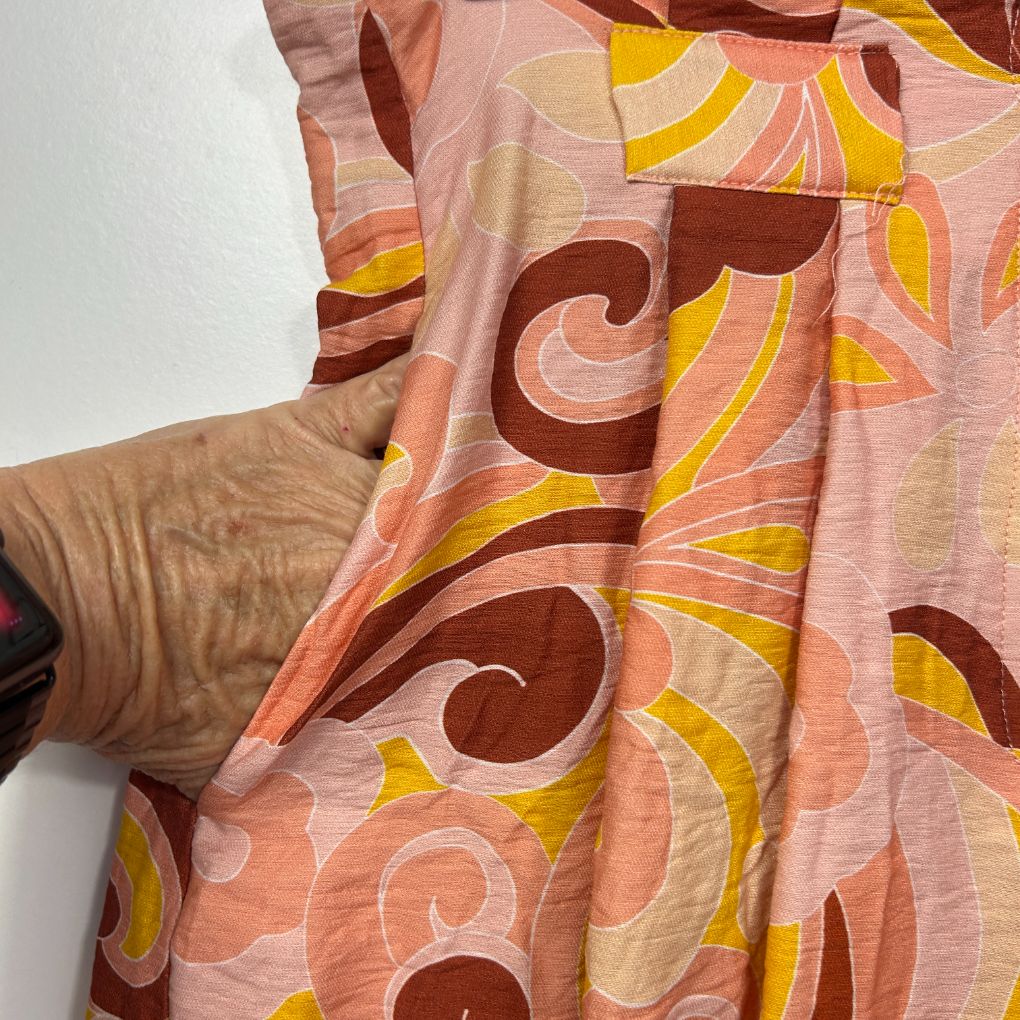 Pink shirt with brown and yellow graphic pattern detail view