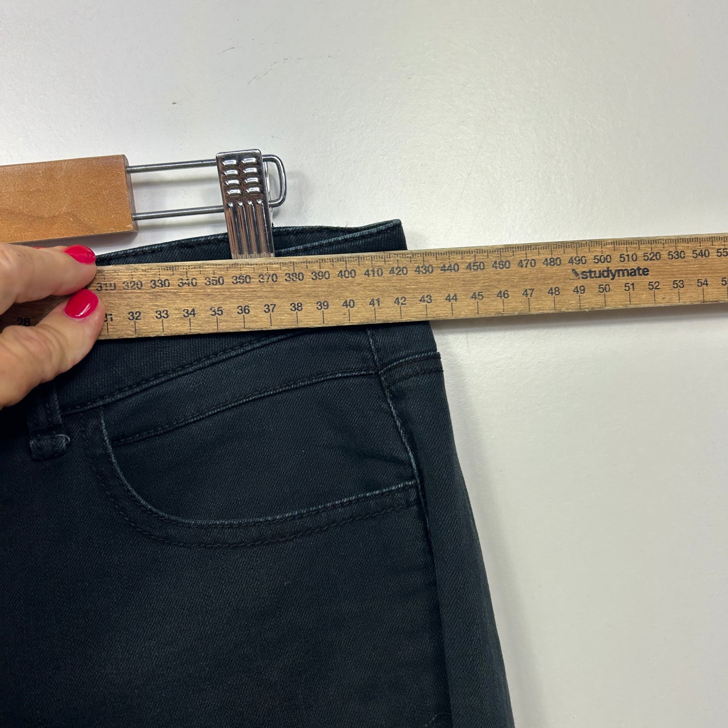 Navy jeans waistband detail view with measuring tape