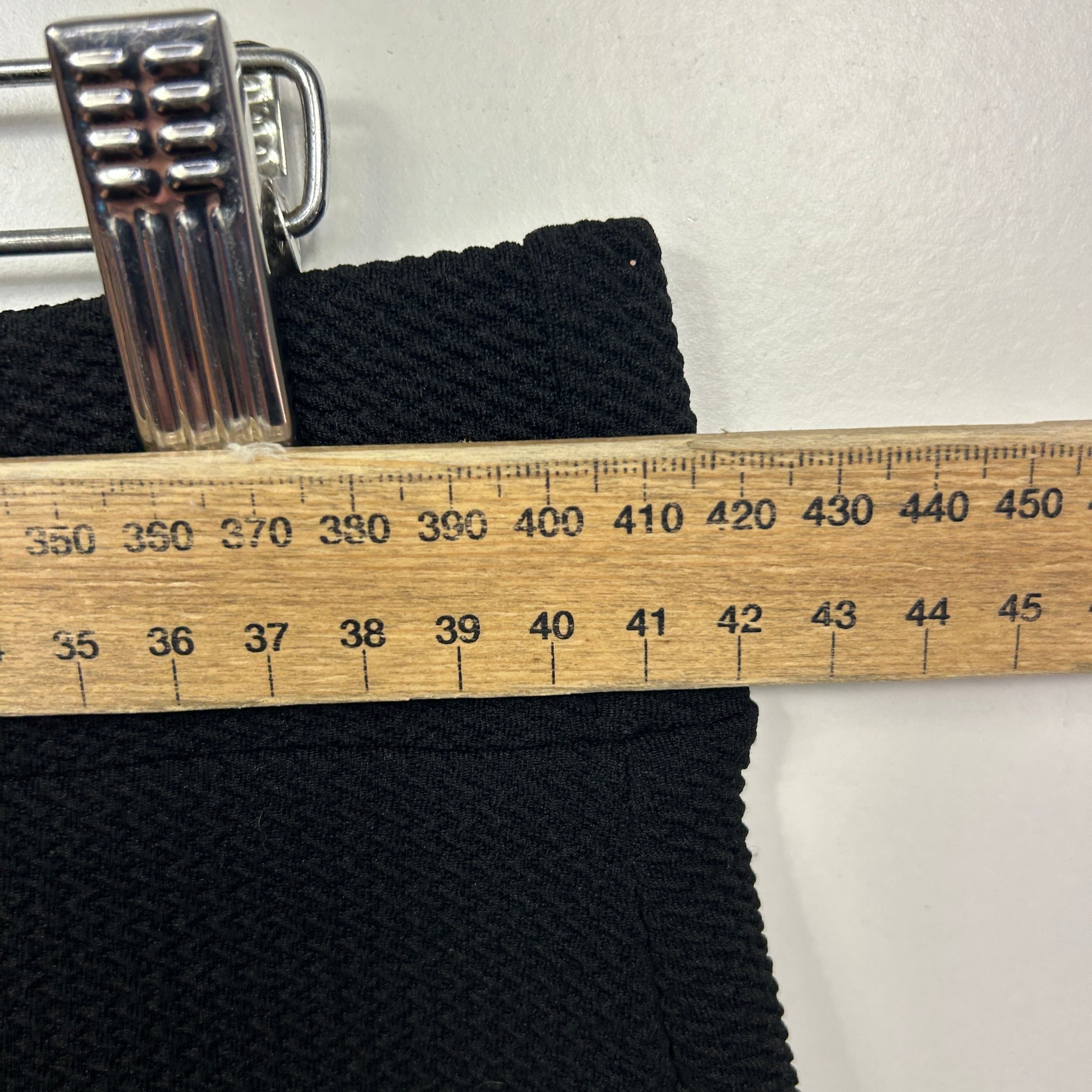 Black knit fabric with measuring tape detail view