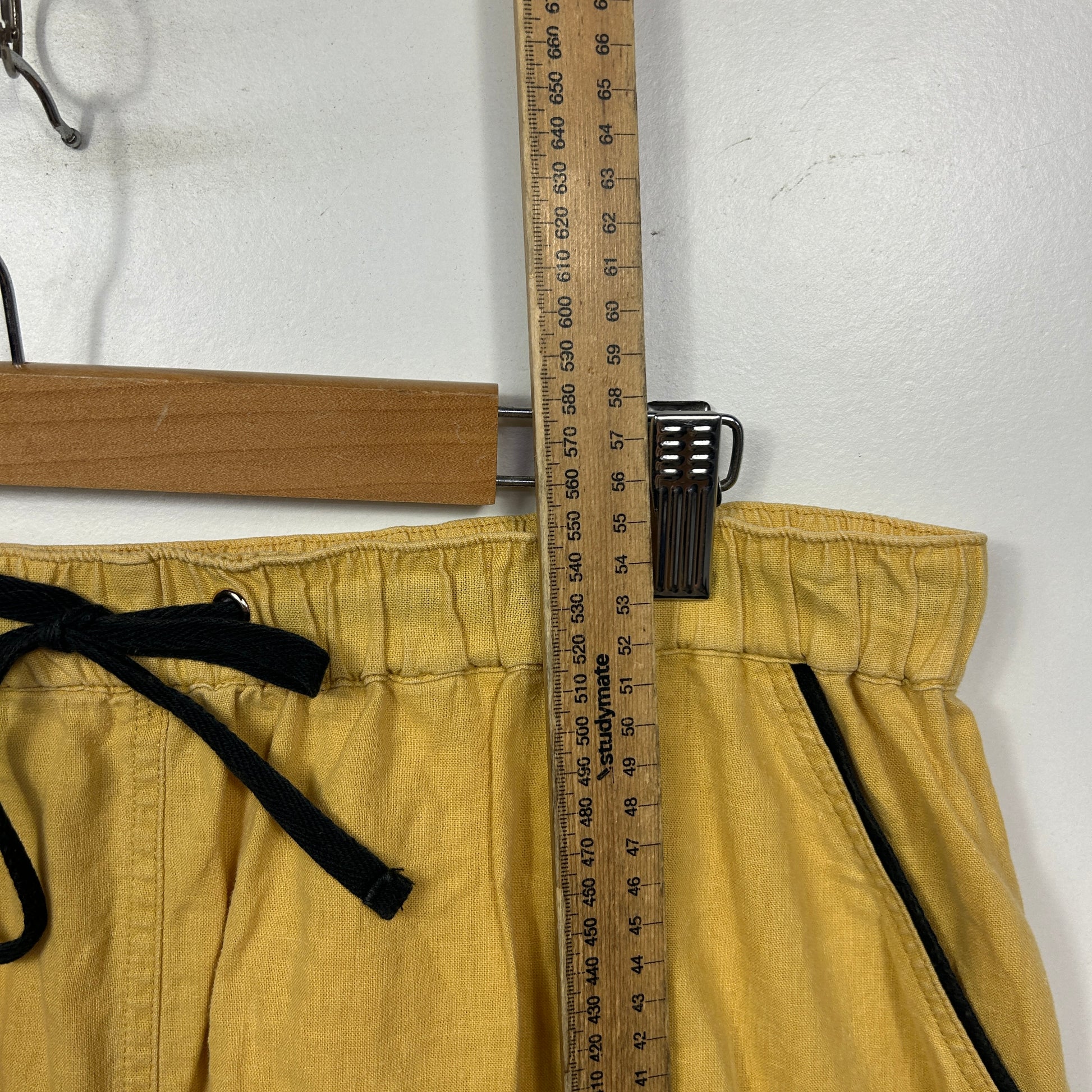 Yellow shorts being measured with ruler detail view