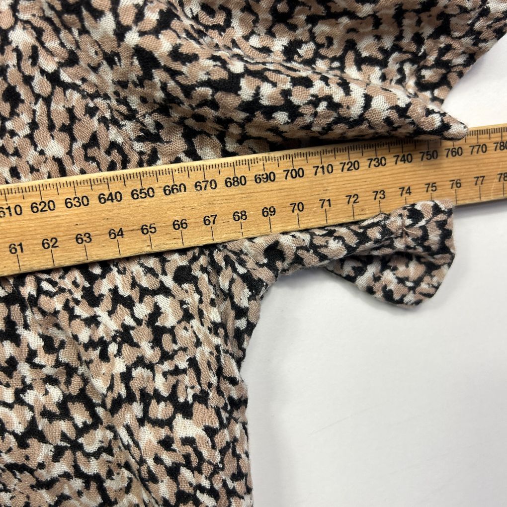 Black and cream patterned fabric detail view with measuring tape