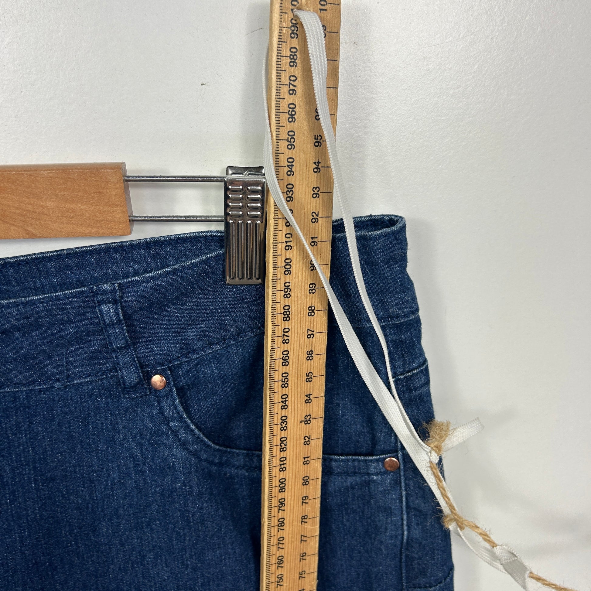 Dark blue denim jeans front view with measuring tape