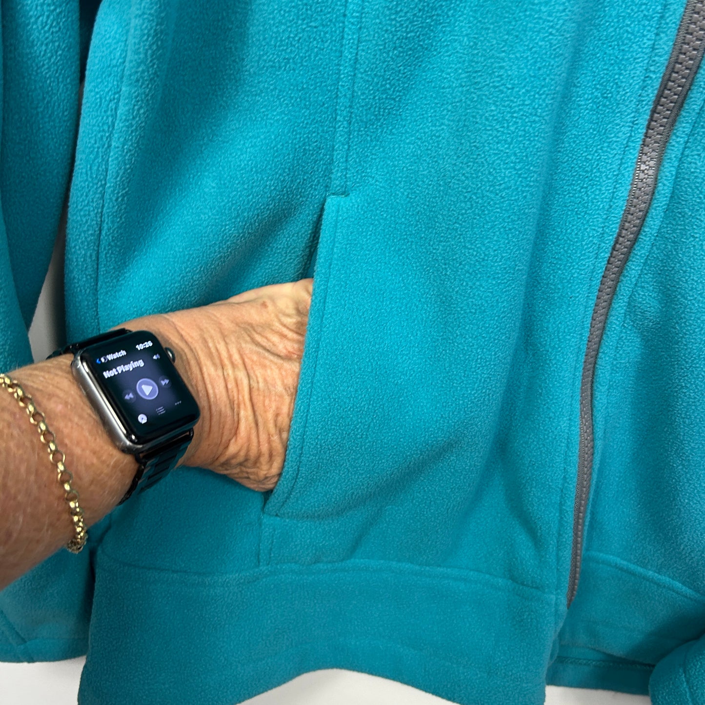 Teal fleece hoodie detail view on model wearing smartwatch