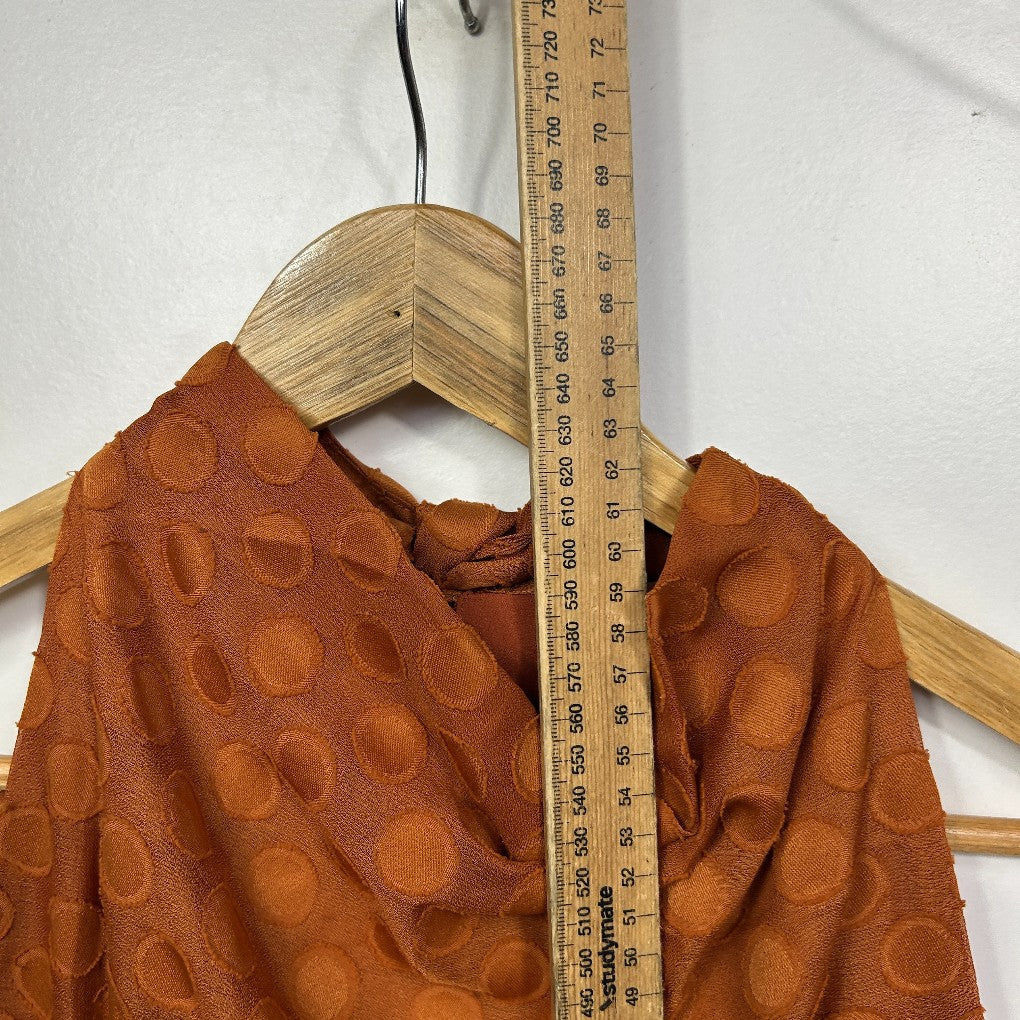Rust orange long sleeve top with circular pattern detail view