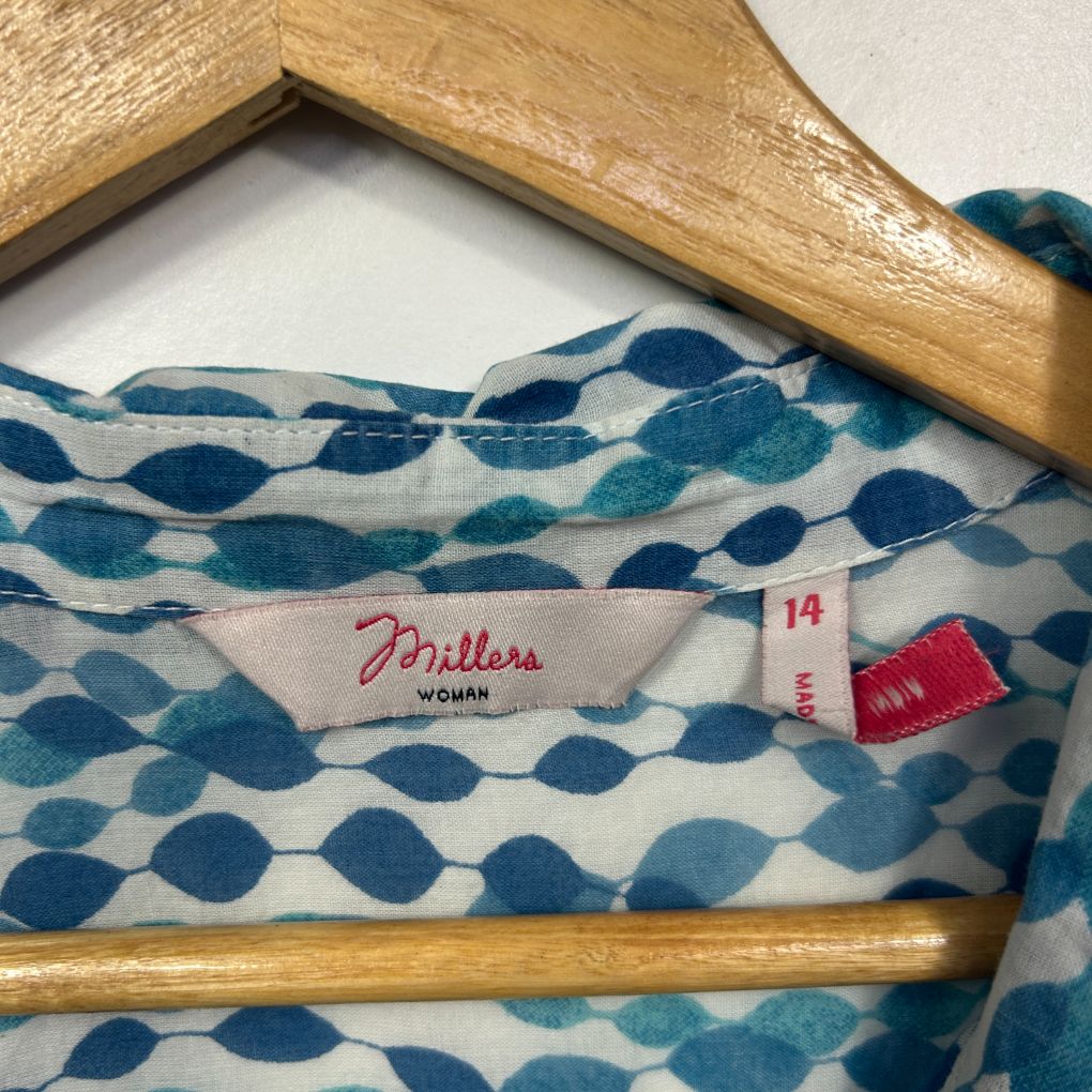Blue and white patterned top on wooden hanger label view