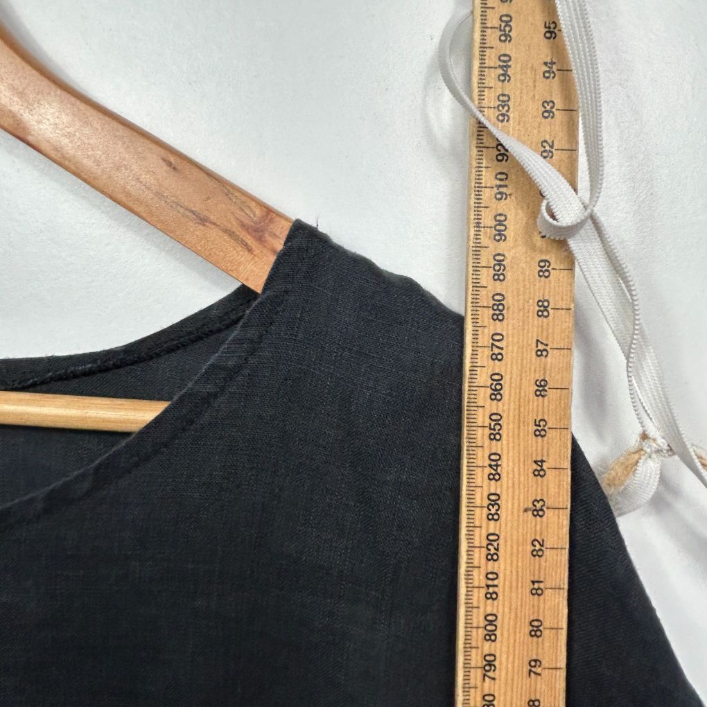 Black t-shirt front view with wooden hanger and measuring tape
