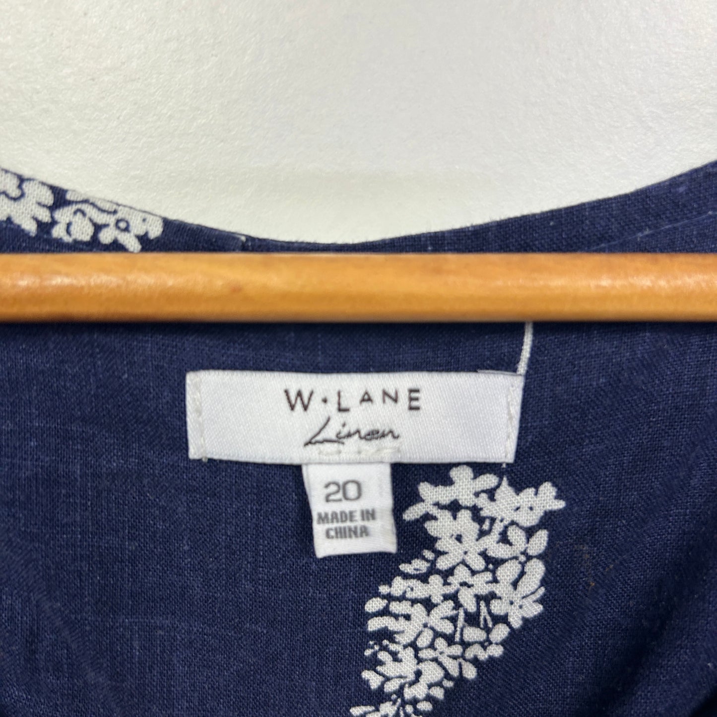 Navy blue top with white floral graphic detail and size 20 label