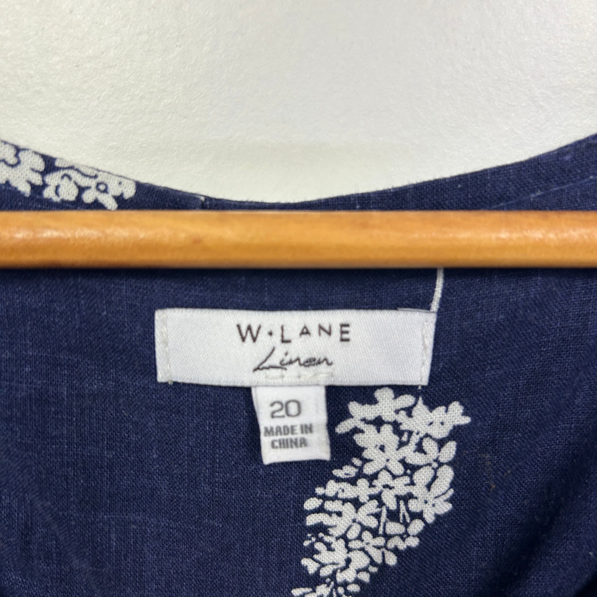 Navy blue top with white floral graphic detail and size 20 label