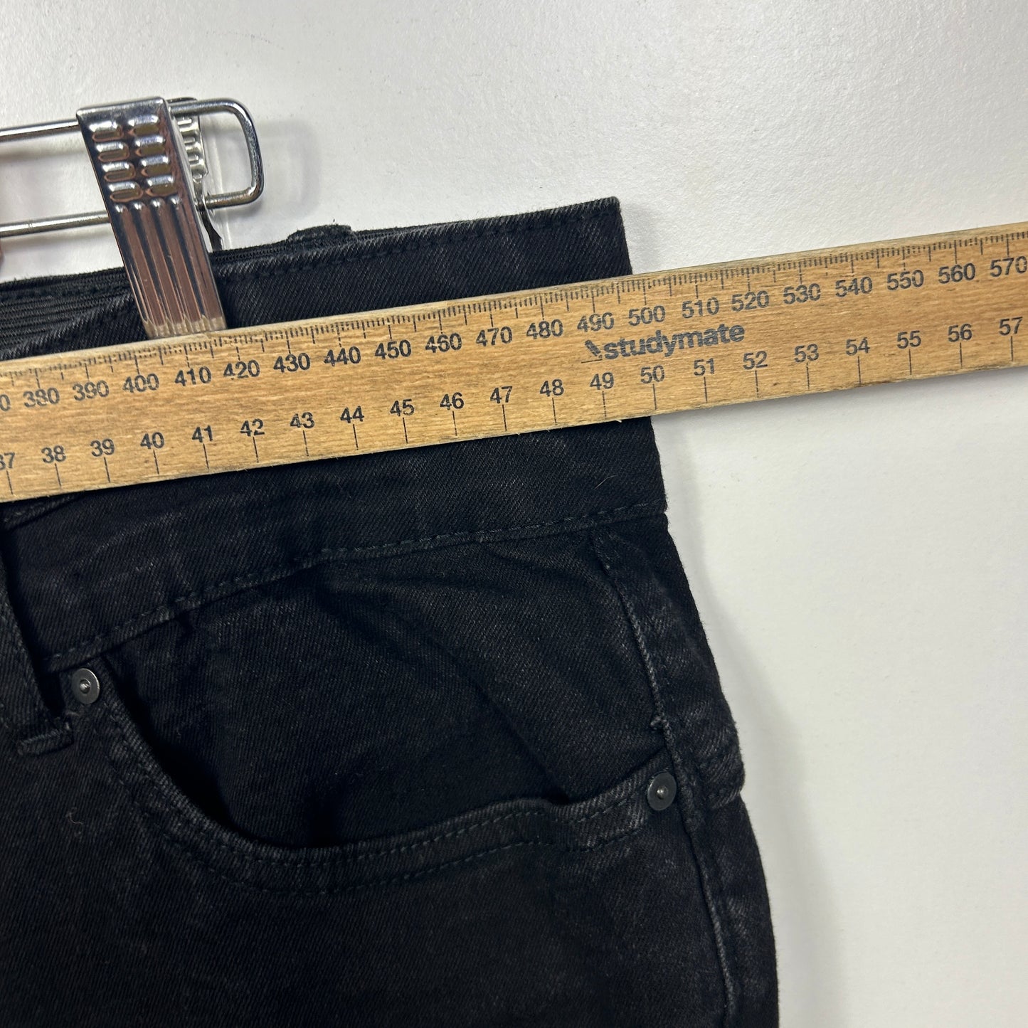 Dark navy jeans waistband detail with measuring tape
