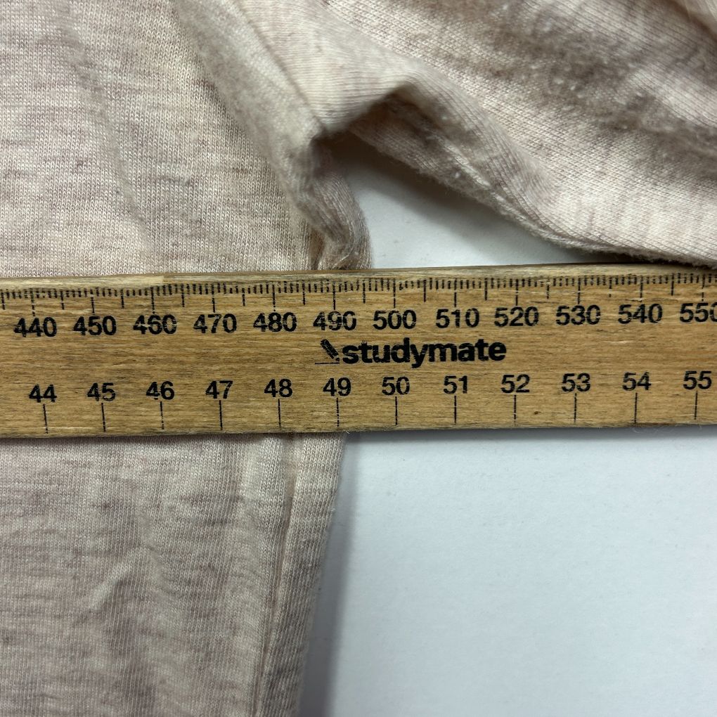 Beige knit fabric detail view with measuring ruler
