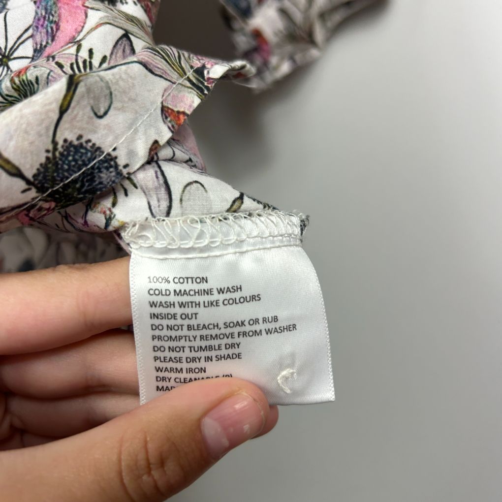 White floral garment label detail view