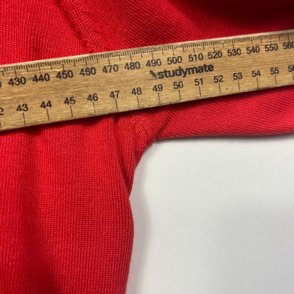Red knit fabric with measuring tape detail view