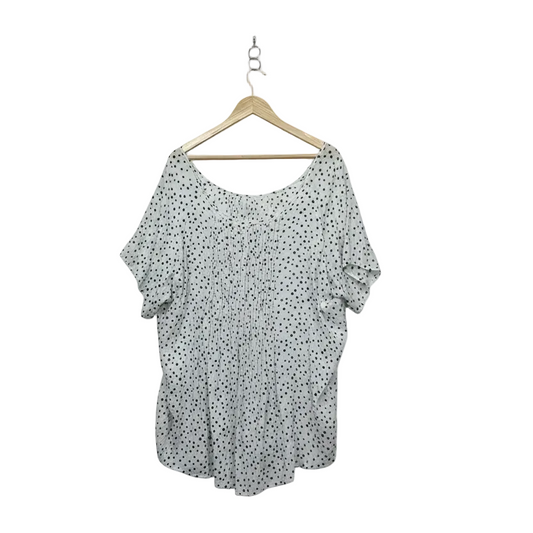 White polka dot oversized top on hanger